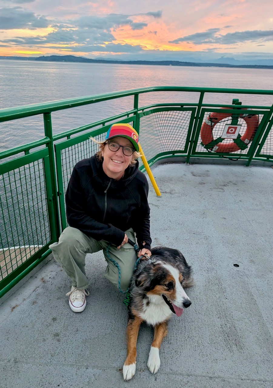 Jeanne Sickel with her dog on a ferry deck at sunset